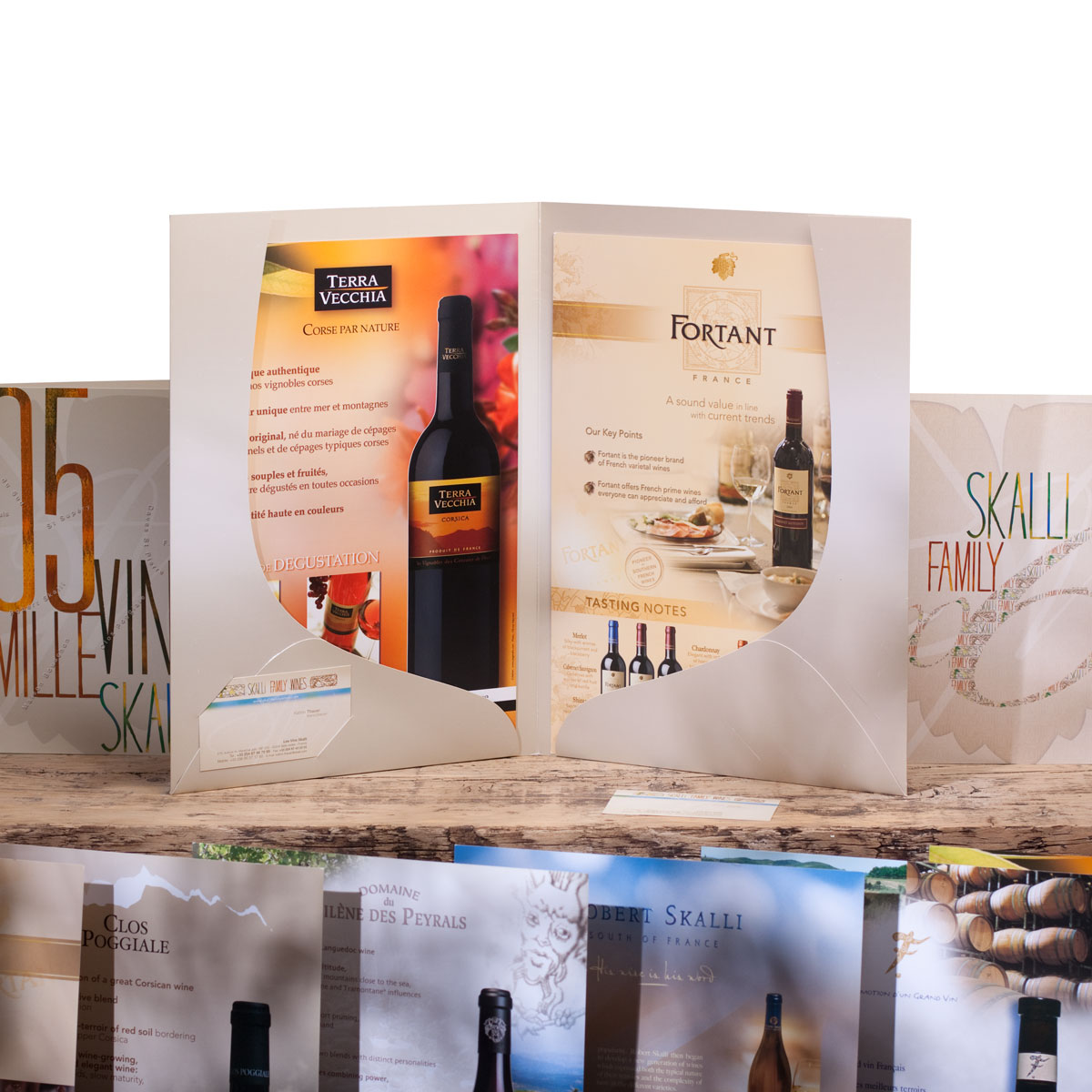 Ensemble de créations graphiques pour les vins Skalli : Design de pochette chemise avec découpe sur mesure, création de plaquettes de vin, fiches d'aide à la vente, design des cartes de visite